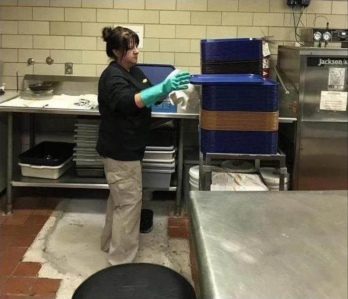 Janitorial Technician Cleaning Plastic Trays in a Commercial Kitchen 