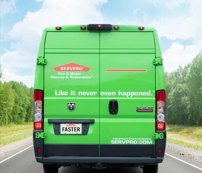 Back of a green SERVPRO truck with a "faster" license plate