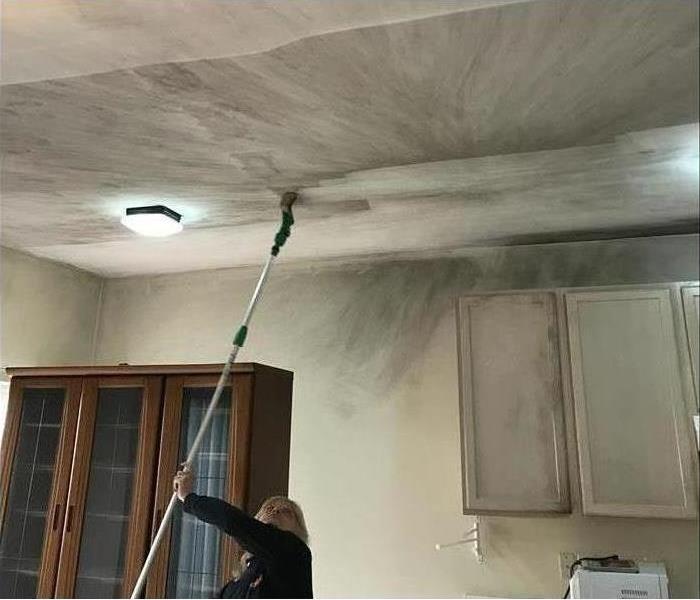 Technician cleaning heavy soot in a home with a chem sponge